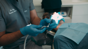 News 10 Dental professional performing a dental procedure with dental tools and patient in chair at Hewett’s Dental in Brighouse, Huddersfield, Halifax, Bradford.